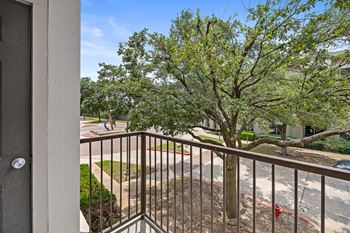 a balcony with a view of a tree and a street at Artisan Apartments & Shops, Austin